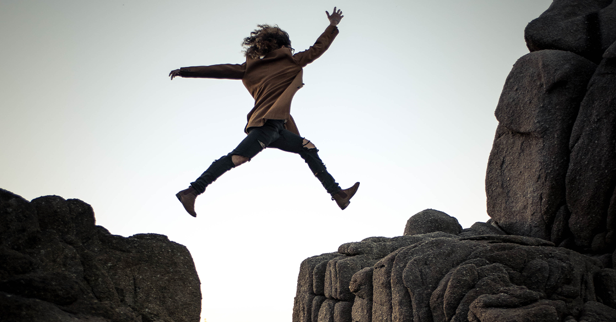 Person jumping between rocks